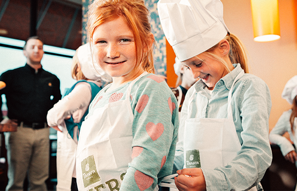 Bakers In Training Students tying on their aprons.